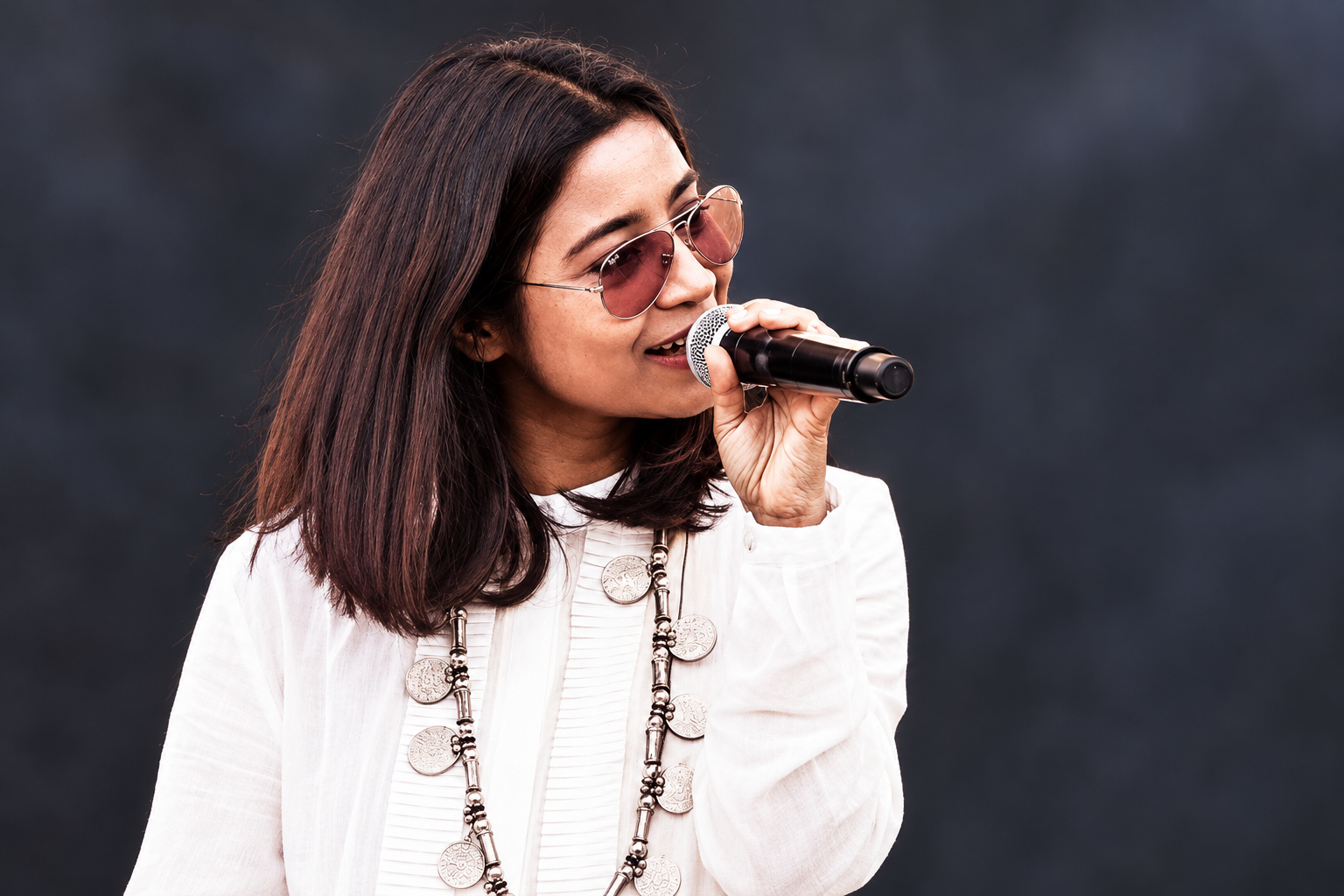 AI-modified 2021 archive photograph of Shilpa Rao holding a microphone; not the reported Mumbai event.